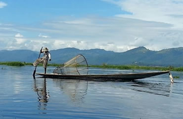 Fisherman rowing with a leg